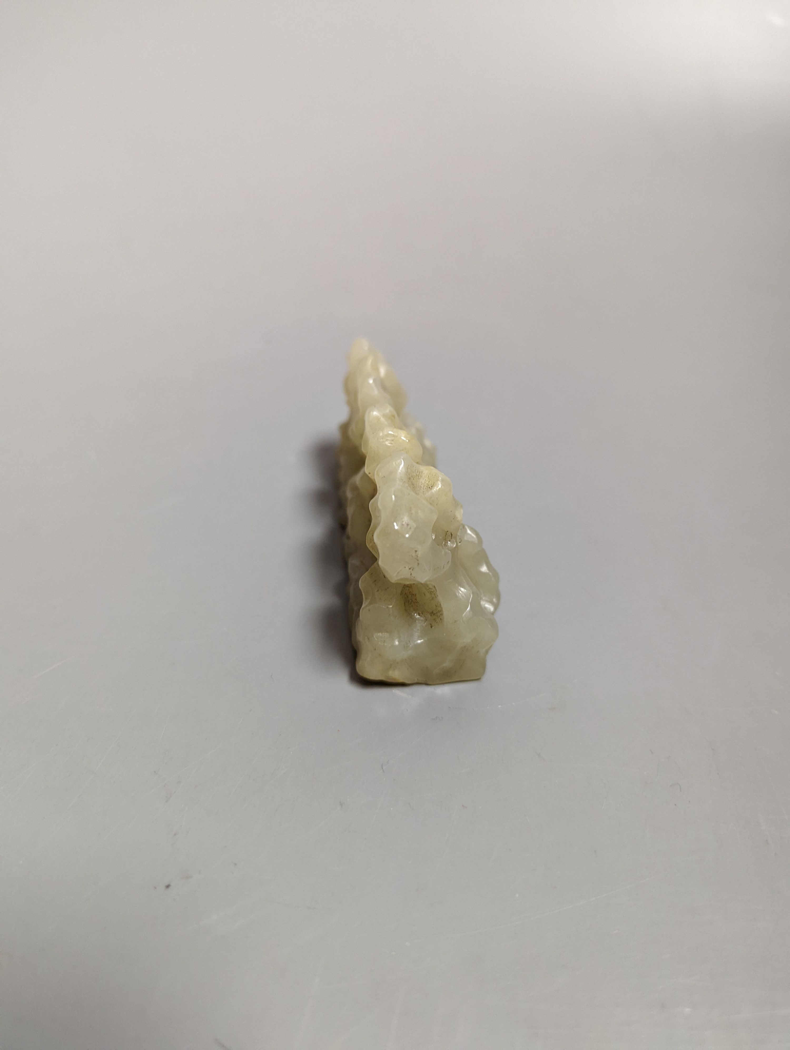 A Chinese celadon jade brush rest, 8cms wide